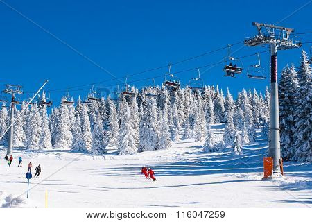 Ski resort Kopaonik, Serbia, ski lift, skier and snowboarder on the piste