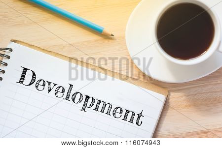 Concept Development message on book. A pencil and a glass coffee table.