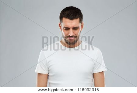 unhappy young man over gray background