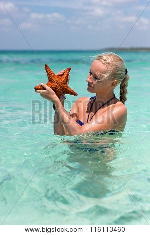 Woman Holding Two Starfishes In Her Hands