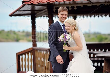 Happy Bride And Groom On A Walk By The Lake