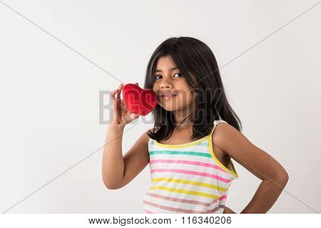 small girl with stuffed heart, stuffed heart and girl, indian girl holding stuffed heart, asian girl