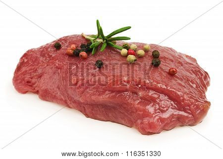Raw ribeye steak garnished with a sprig of rosemary