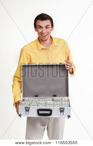 Young businessman with suitcase full of money.