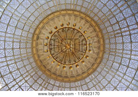 Gold Chandelier Under A Glass Dome In The Interior