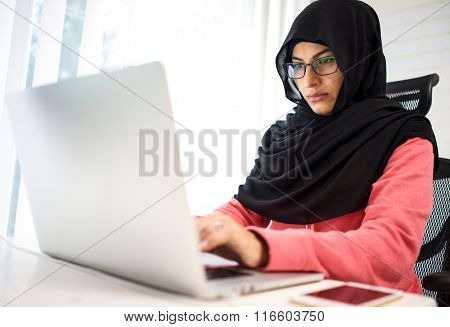 Attractive Muslim young woman working in office on computer