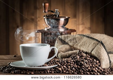 still life with coffee beans and old coffee mill on the wooden background 