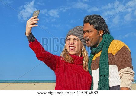 interracial couple of friends take selfie photo with smartphone
