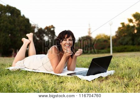 Young Woman Using Laptop In Park