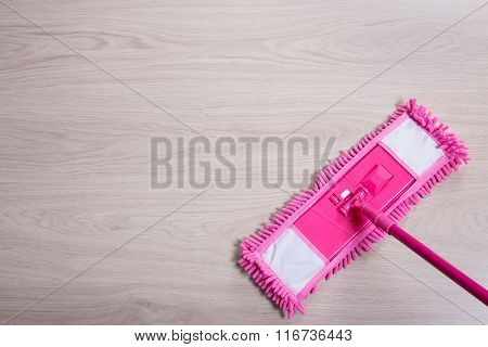 Close Up Of Pink Floor Mop On Wooden Background