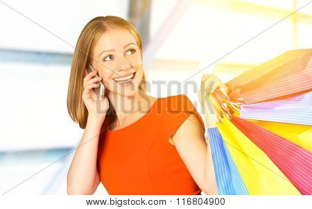 Happy Woman With  Bags On Shopping And Kredit Card Talking On Phone