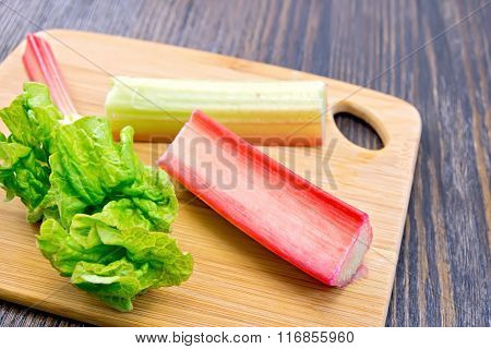 Rhubarb with leaf on dark board