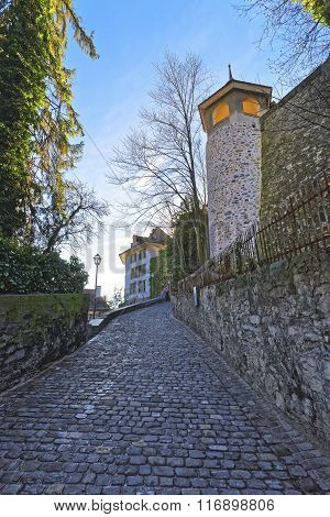 Small Cobblestone paved road in the Old City of Thun. Thun is a city in Swiss canton of Bern where Aare river flows out of Lake Thun. Town Hall Square is a historic center of the city