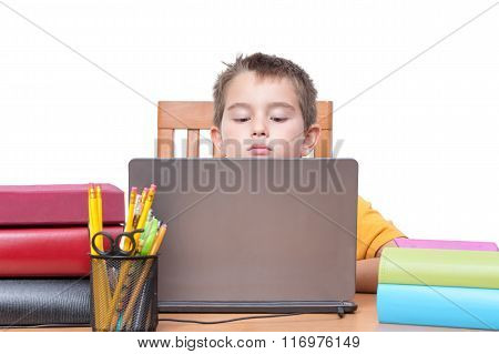 Young Boy On Laptop Studying At Desk With Books