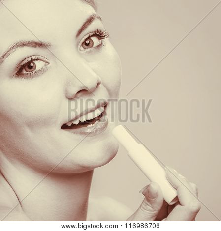 Young Woman Take Balm On Lips.