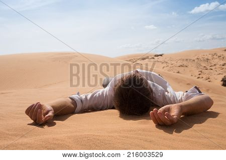 Man lie alone in the sunny desert. He is lost and out of breath. No water and energy. Concept for depression and noway situation in life