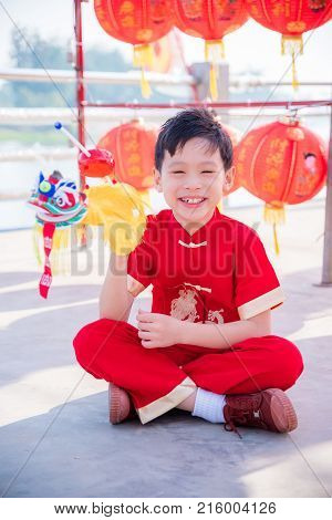 Young chinese boy wearing traditional dreass and playing lion puppet in chinese new year festival