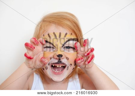 Red-haired girl with painted face tiger on the white background