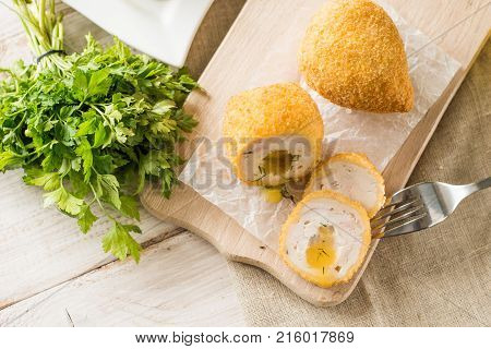 Chicken Kiev cutlets with parsley leaves and butter.
