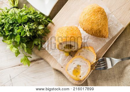 Chicken Kiev cutlets with parsley leaves and butter.