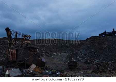 Huge garbage dump of various metal waste and boards against a stormy sky