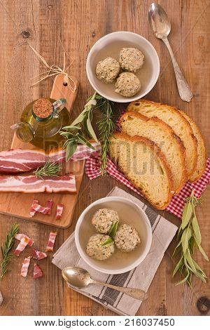 Canederli pasta with bacon on wooden table.