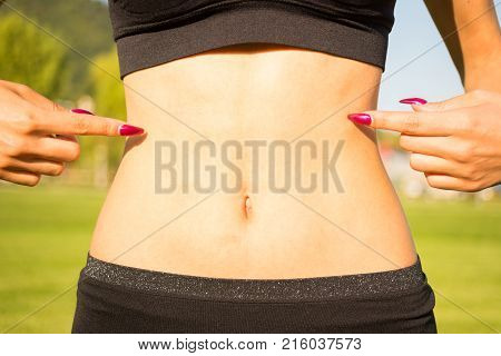 Closeup Of Woman Pointing Finger At Her Tummy