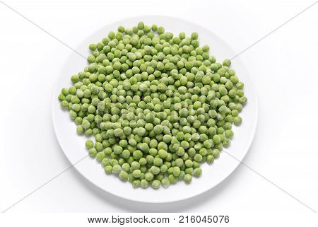 Frozen green peas on a plate isolated on white background