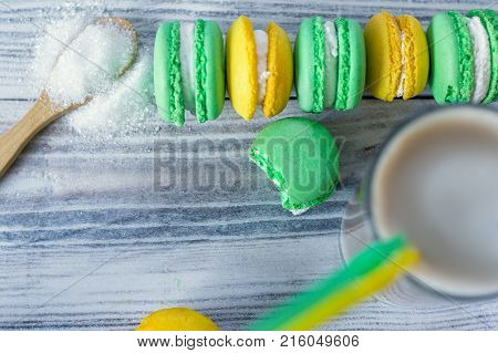 colorful macaroons are laid in a row and latte in a glass