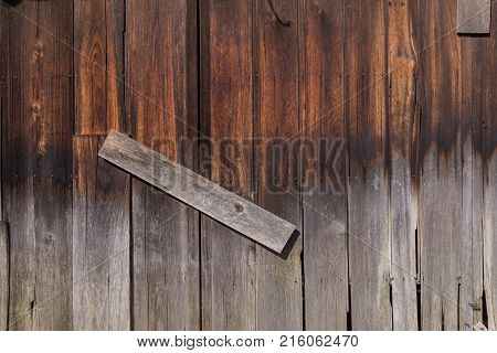 Old aged japanese red pine wood with decay and pale color at the bottom half in day light using as texture or background.