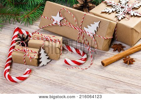 Christmas time concept Christmas gifts and traditional New Year sweets candy cane on wooden bachground. Top view copy space.