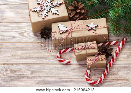 Christmas time concept Christmas gifts and traditional New Year sweets candy cane on wooden bachground. Top view copy space.