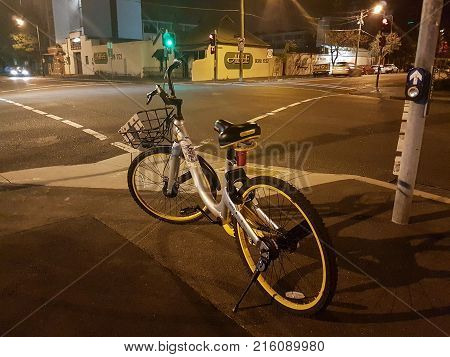 SYDNEY AUSTRALIA - NOVEMBER 26 2017; Abandoned dockless bike-sharing cycle at city intersection at night.