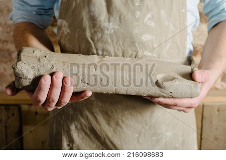 Potter Tools Ceramics Art Concept - Smiling Brunette Man With A Beard Dressed In An Apron Hands Of Y