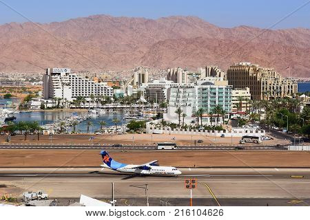 Eilat, Israel - MAY 24: plane of israeli airline Israir, landed at the airport of Eilat on the background of luxurious hotels, Israel, on May 24, 2017 in  Eilat, Israel