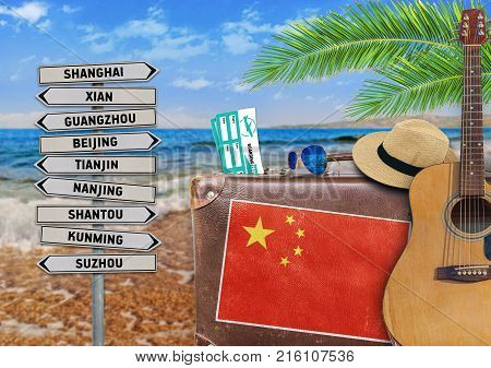 Concept of summer traveling with old suitcase and China town sign