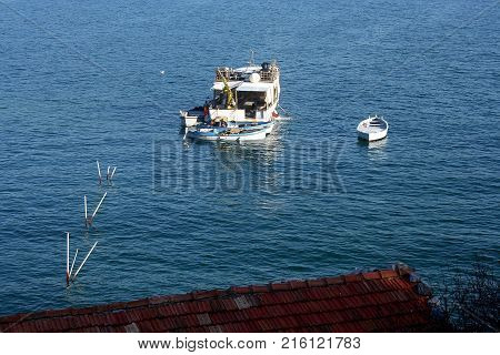 Fishing boat and small boat in the blue sea of the island Palmaria