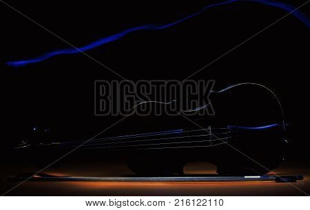 Accentuated shapes of violin with light illuminated in dark.