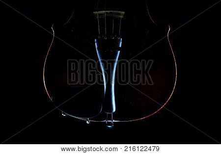Accentuated shapes of violin with light illuminated in dark.