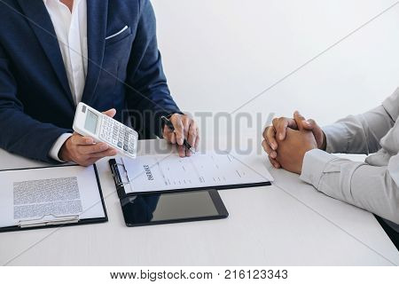 Businessman being analysis and making the decision a car insurance policy Agent man is using calculator to presentation detail and waiting for his reply to finish.