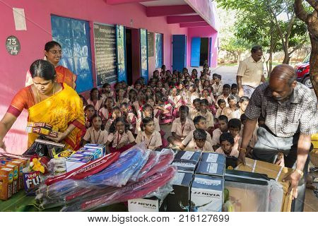PONDICHERY PUDUCHERY INDIA - SEPTEMBER 04 2017. Outdoor meeting of the children of the school with uniforms sitting on the floor waiting for sport equipments as a gift from an association.