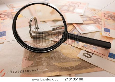 Background with euro money. Magnifier focused on keys. Euro banknotes. 50 euro.