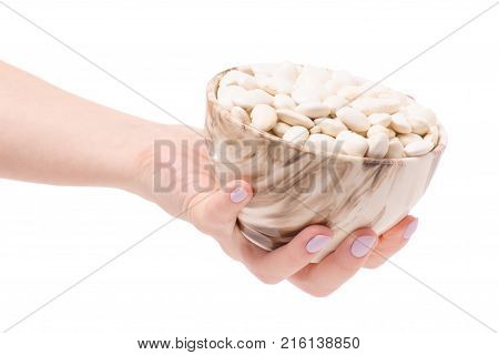 White beans in a pial plate of female hands on a white background isolation