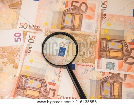 Background with euro money. Magnifier focused on keys. Euro banknotes. 50 euro.