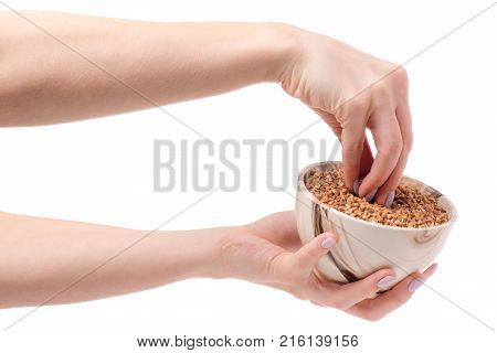 Buckwheat groats in a plate pial female hands on a white background isolation
