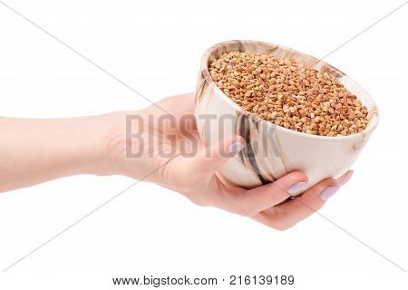 Buckwheat groats in a plate pial female hands on a white background isolation