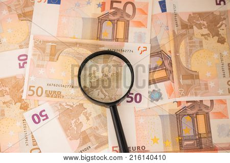 Background with euro money. Magnifier focused on keys. Euro banknotes. 50 euro.