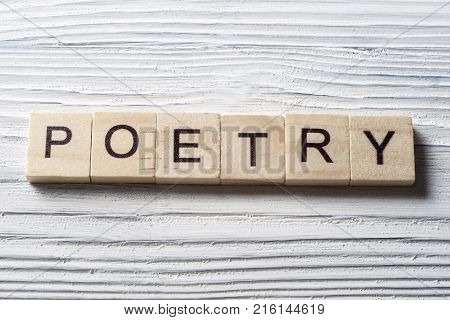 Word POETRY written on wooden cubes on the table.Wood ABC.