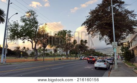 Honolulu - June 28 2016: Cars drive down Kapahulu Ave at Dusk on Oahu.