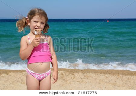 little girl eat ice cream on the beach